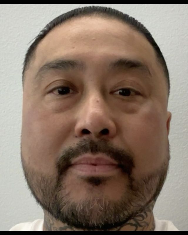 Close-up portrait of barber Dexter “Dex” Pecson, with a trimmed beard and mustache